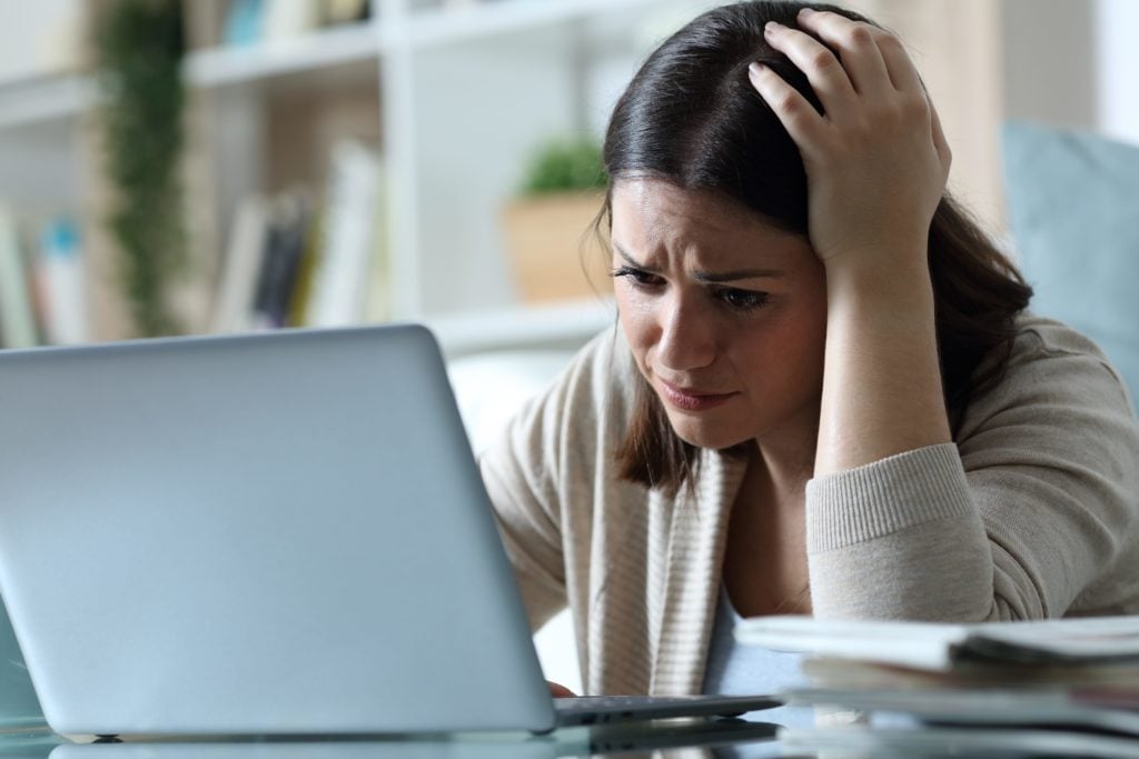 smutna kobieta sprawdza na laptopie fake newsy spoofing