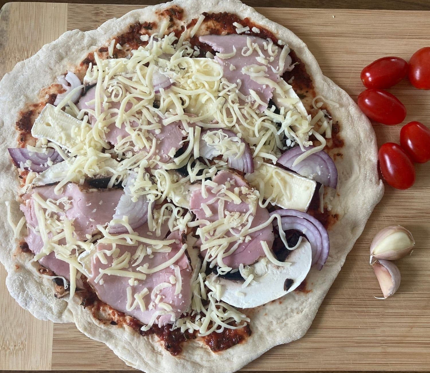 pizza z szynką przygotowana do pieczenia