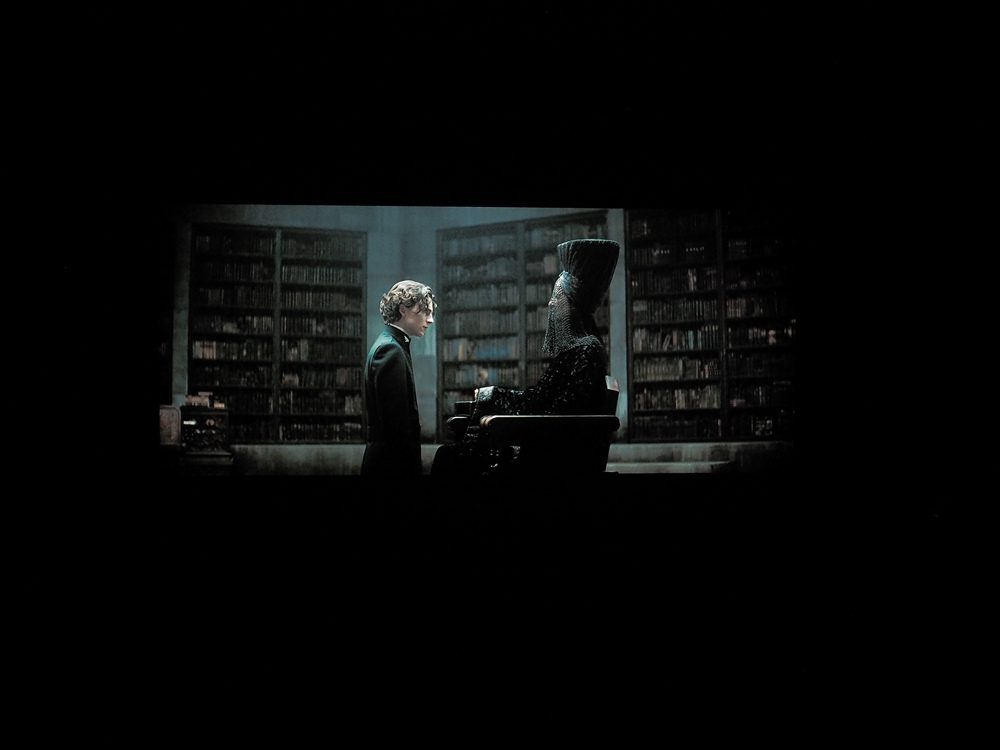 młody mężczyzna w ciemnym pomieszczeniu, skąpe światło skupia się w centralnym punkcie obraz