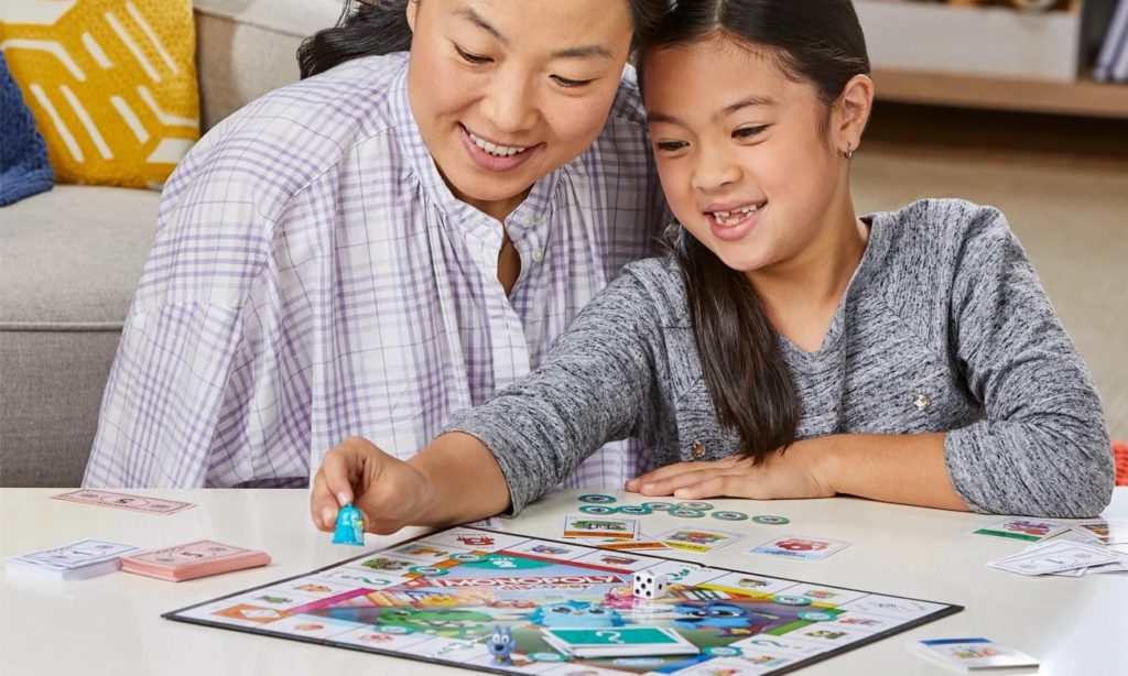 Kobieta dziewczynka grają w Monopoly zabawki kreatywne Hasbro