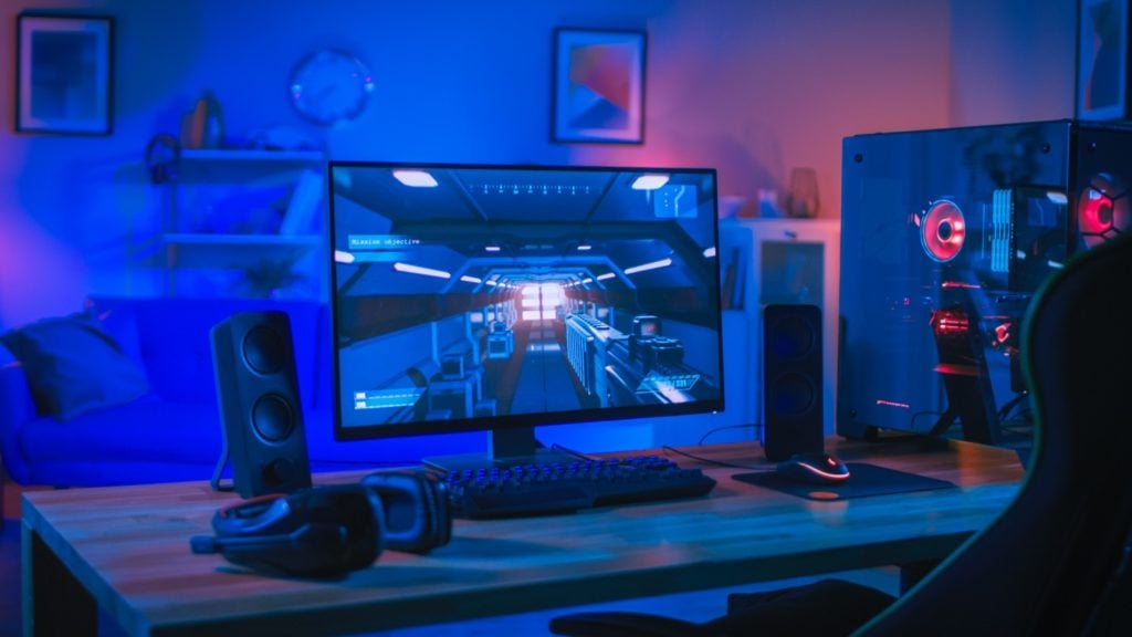 Monitor do grania na biurku obok komputera gamingowego